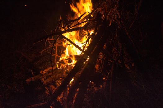 Firecamp at the night time. Hot fireplace full of wood and fire burning, closeup