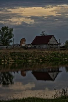 The old house by the pond. A house by a pond.