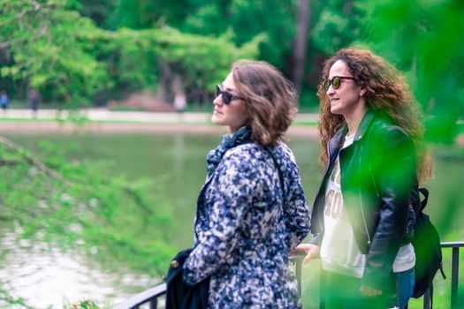 Happy women on vacations watching a lake, happy.