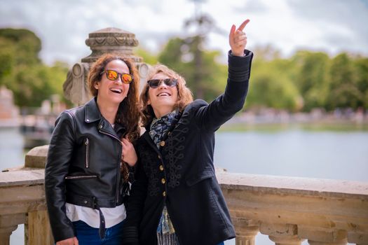 Two women sightseeing, smile looking at somethings that makes them funny.