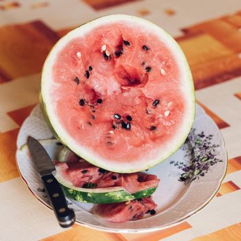 Fresh juicy watermelon with knife on the desk.