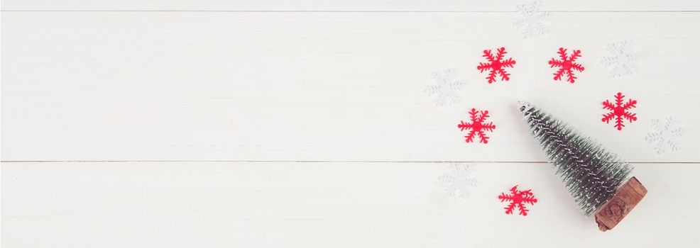 Christmas holiday composition decoration with pine tree on wooden background, new year and xmas or anniversary with presents and snow sign on wood table, flat lay, copy space, banner website.