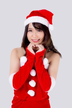 Beautiful portrait young asian woman Santa costume wear hat smiling gesture heart with hand in holiday xmas, beauty model asia girl cheerful celebrating in Christmas isolated on white background.