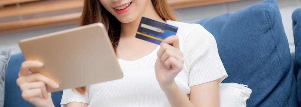 Hand of young asian woman holding credit card shopping online with tablet computer buying and payment, girl using debit card purchase or transaction of finance, e-commerce concept, banner website.