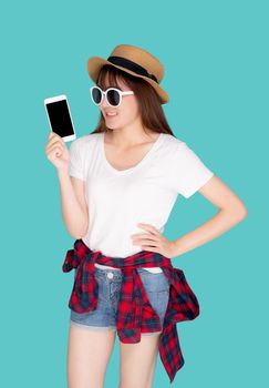 Beautiful young asian woman showing smart mobile phone for presenting something in travel summer trip in vacation isolated on blue background, asia girl holding smartphone, holiday concept.