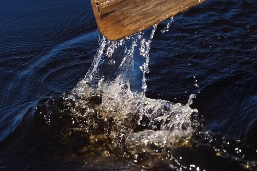 Paddle over the surface of the water. Rowing a paddle in the river.
