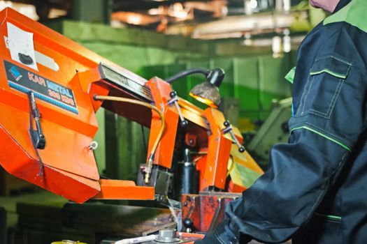 Moscow, Russia - January 23, 2019: The worker stands at the machine on the sharpening of parts.