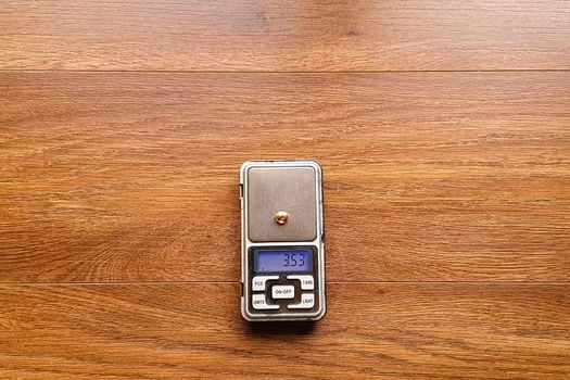 A small piece of gold on an electronic scale.