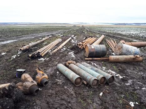 Metal left over from the drilling of a well in the tundra. Barrels, cylinders and chisel balls