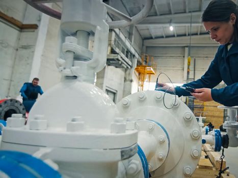 Moscow, Russia - January 23, 2019: The worker measures the thickness of the pipe. Checking the pipes at the plant.