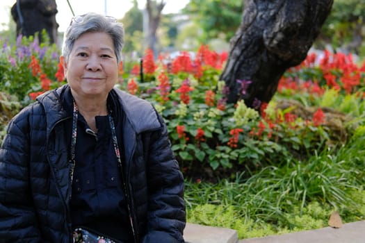 asian old elderly female elder woman resting relaxing in garden. senior leisure lifestyle