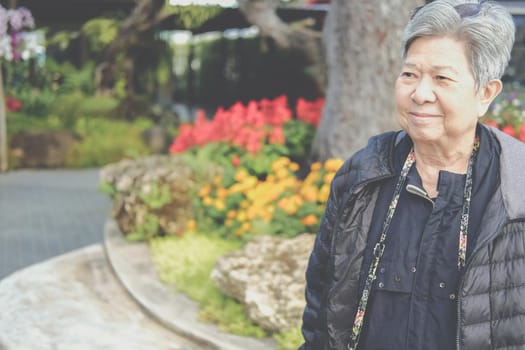 asian old elderly female elder woman resting relaxing in garden. senior leisure lifestyle