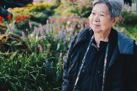 asian old elderly female elder woman resting relaxing in garden. senior leisure lifestyle