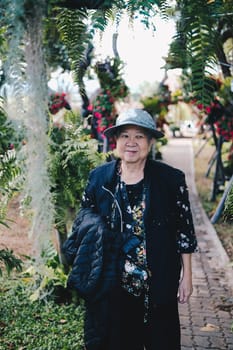 asian old elderly female elder woman resting relaxing in garden. senior leisure lifestyle