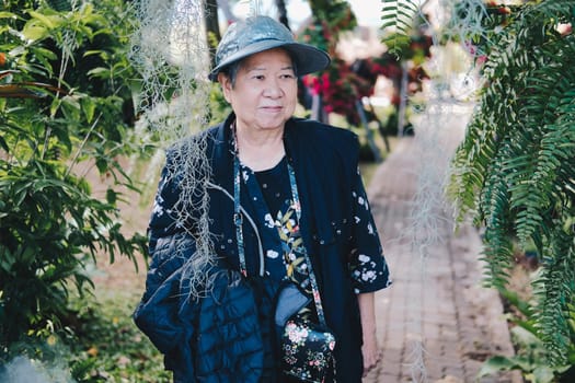 asian old elderly female elder woman resting relaxing in garden. senior leisure lifestyle