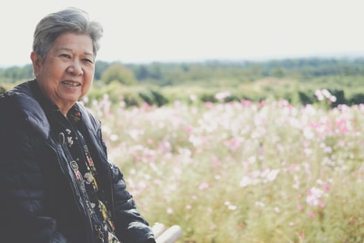 asian old elderly female elder woman resting relaxing in garden. senior leisure lifestyle