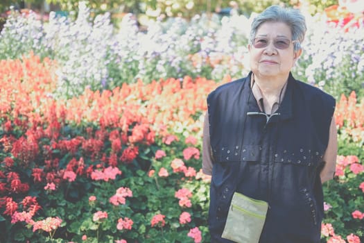 asian old elderly female elder woman resting relaxing in garden. senior leisure lifestyle