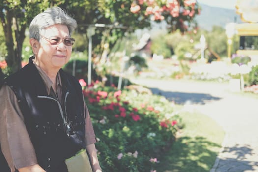 asian old elderly female elder woman resting relaxing in garden. senior leisure lifestyle