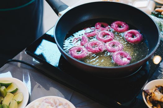 frying purple sweet potato doughnut. deep fried doughnuts dessert