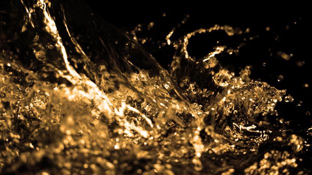 Hi speed close up images of oil liquid from diesel gasoline splashing and moving up to the air on black background for represent power of fuel liquid that active and powerful. studio shot premium gold color tone.