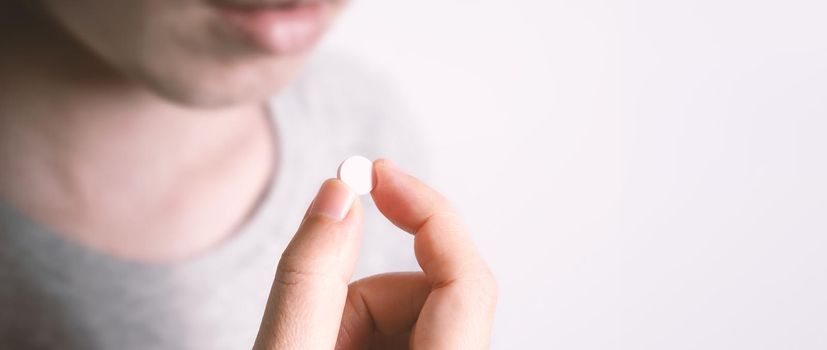 People taking or holding a white medicine pill in hand which help and protect from pandemic virus and relief them from unhealthy and sickness. studio close up shot and clear background.