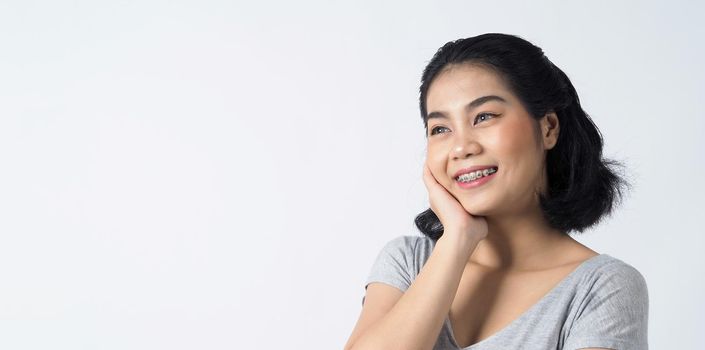 Dental braces of teen asian woman wearing braces teeth and contact lenses, she very confident and proudly present herself and smile on white background studio shot, Happiness teenager smiling facial expression.