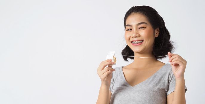 Dental brace teen girl smiling looking on a camera. white teeth with blue braces. Dental care. Asian woman smile with orthodontic accessories. Cosmetic dentistry, orthodontics treatment. studio shot.