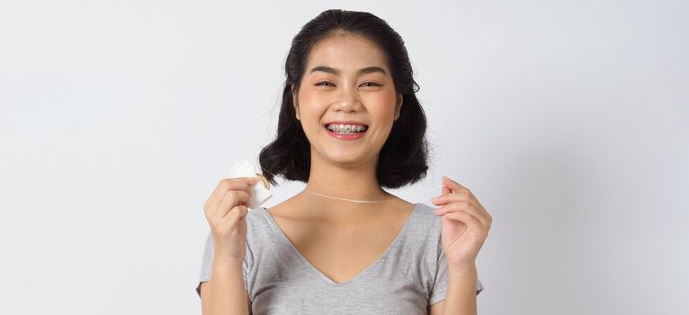 Dental brace teen girl smiling looking on a camera. white teeth with blue braces. Dental care. Asian woman smile with orthodontic accessories. Cosmetic dentistry, orthodontics treatment. studio shot.