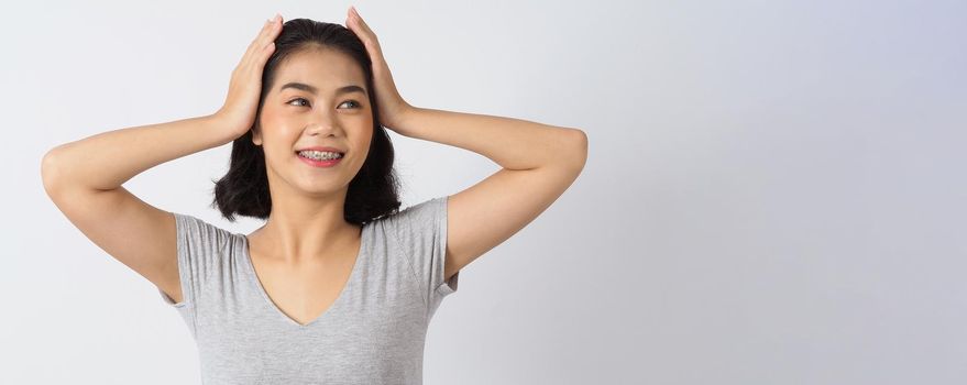 Dental brace teen girl smiling looking on a camera. white teeth with blue braces. Dental care. Asian woman smile with orthodontic accessories. Cosmetic dentistry, orthodontics treatment. studio shot.