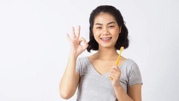 Dental brace teen girl smiling looking on a camera. white teeth with blue braces. Dental care. Asian woman smile with orthodontic accessories. Cosmetic dentistry, orthodontics treatment. studio shot.