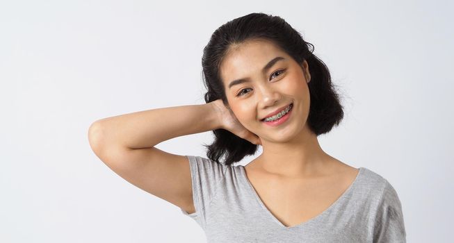 Dental brace teen girl smiling looking on a camera. white teeth with blue braces. Dental care. Asian woman smile with orthodontic accessories. Cosmetic dentistry, orthodontics treatment. studio shot.