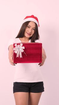 Girl hold gift box make selfie or video online with x-mas christmas prop decoration. Asian Thai teen woman taking online-selfie to celebrate festive season with her friend by red giftbox. studio shot.