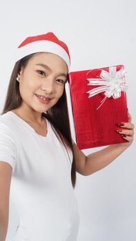 Girl hold gift box make selfie or video online with x-mas christmas prop decoration. Asian Thai teen woman taking online-selfie to celebrate festive season with her friend by red giftbox. studio shot.