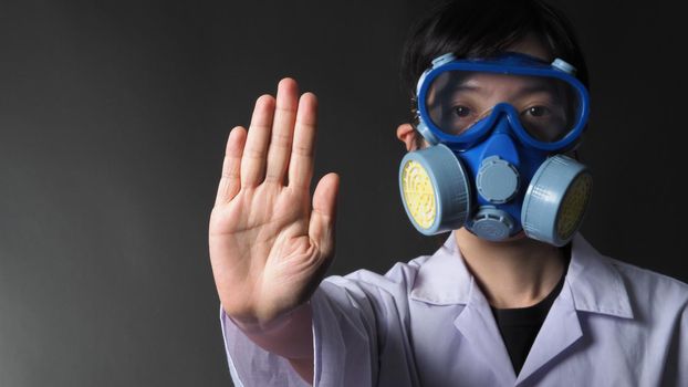 Asian woman doctor in a chemical protective medical mask and protective goggles. Doctor uniform clothing and half mask replaceable particulate filter respirator. Women scientist safety mask