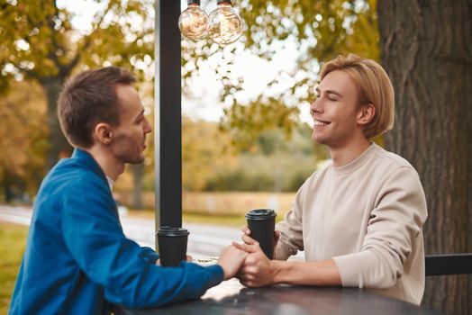 Loving gay couple outdoors. Two handsome men having romantic date in park. LGBT concept.