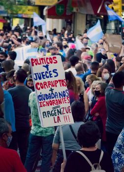 2020-10-12, Mendoza, Argentina: During a protest against the national government, a woman holds a sign that reads "Corrupt judges and politicians + Ignorant citizens = Angenzuela" as a portmanteau between Argentina and Venezuela.