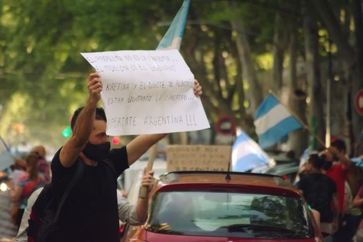 2020-10-12, Mendoza, Argentina: During a protest, a man holds a sign the reads "The problem is not the pandemic, but the government. Wake up, Argentina".