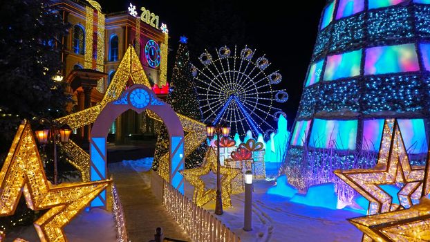 The city is decorated for Christmas and new year. Buildings, garlands, Christmas trees, fences and the square glow with different lights. People relax, enjoy the winter and holiday. Almaty, Kazakhstan