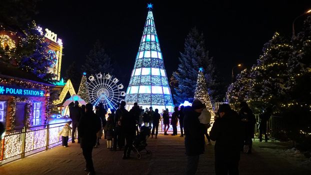 The city is decorated for Christmas and new year. Buildings, garlands, Christmas trees, fences and the square glow with different lights. People relax, enjoy the winter and holiday. Almaty, Kazakhstan