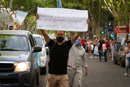 2020-10-12, Mendoza, Argentina: During a protest, a man holds a sign the reads "The problem is not the pandemic, but the government. Wake up, Argentina".
