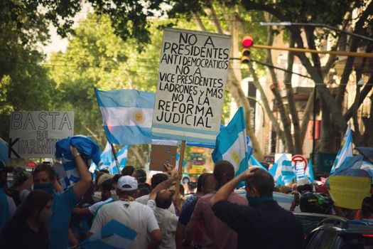 2020-10-12, Mendoza, Argentina: During a protest against the government, a man holds a sign reading "No to antidemocratic presidents, no to thieving vicepresidents, no to the judicial reform"