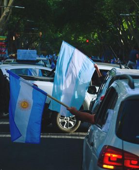 2020-10-12, Mendoza, Argentina: A man holds an argentinian flag from his car during a protest against the national government.