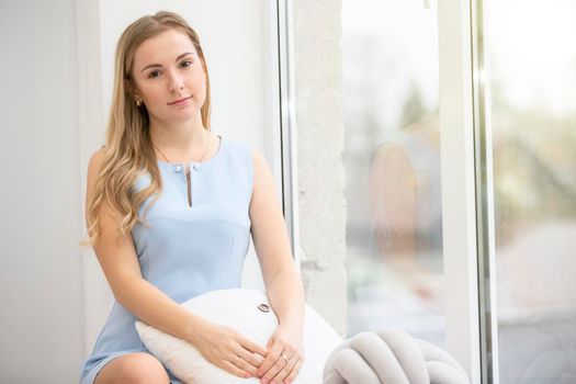 Young ordinary woman at home near the window.