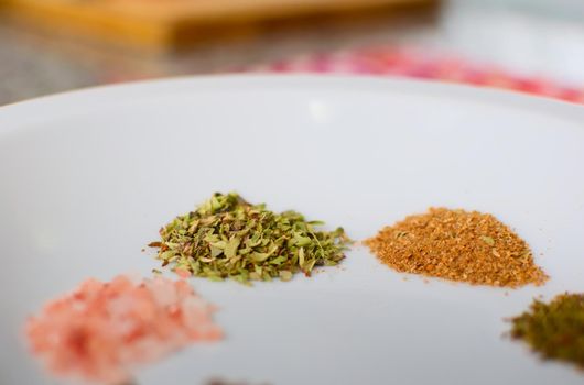 Dried oregano and cumin on a dish. Extreme close up.
