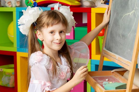 Girl preschooler. Primary school student at the blackboard.
