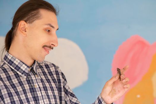 Belarus, the city of Gomel, August 15, 2017. City Terrarium. A man holds a Madagascar cockroach in his hand. Entomologist.