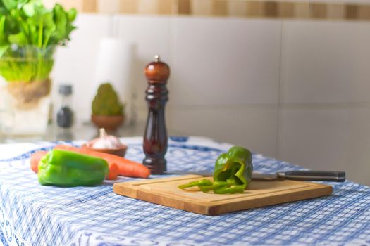 Bell pepper on a cutting board, and fresh ingredients over a kitchen countertop.