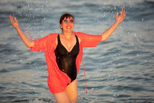 Happy woman at the sea with splashes