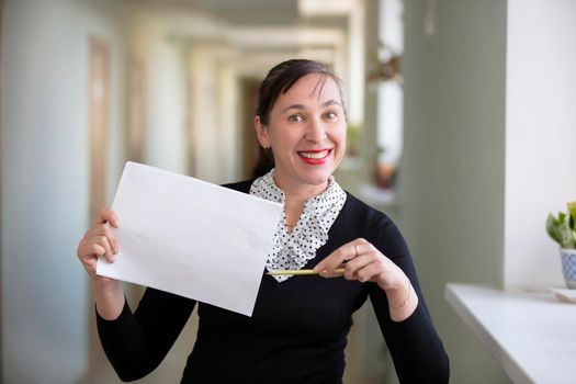 Woman in the office shows on a piece of paper