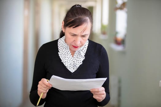 Woman at work. Female employee in the office corridor with paper.